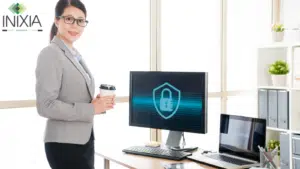 Une femme en tenue professionnelle, un café à la main et dans un Bureau avec deux ordinateurs