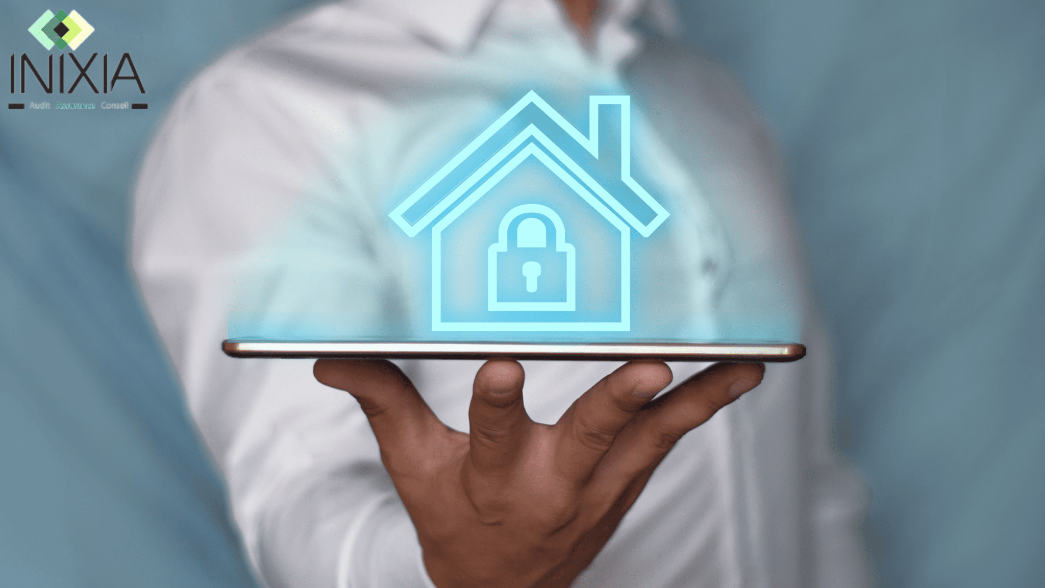 Une personne tient une tablette dans sa main et au-dessus de la tablette, on voit une maison virtuelle en bleu.