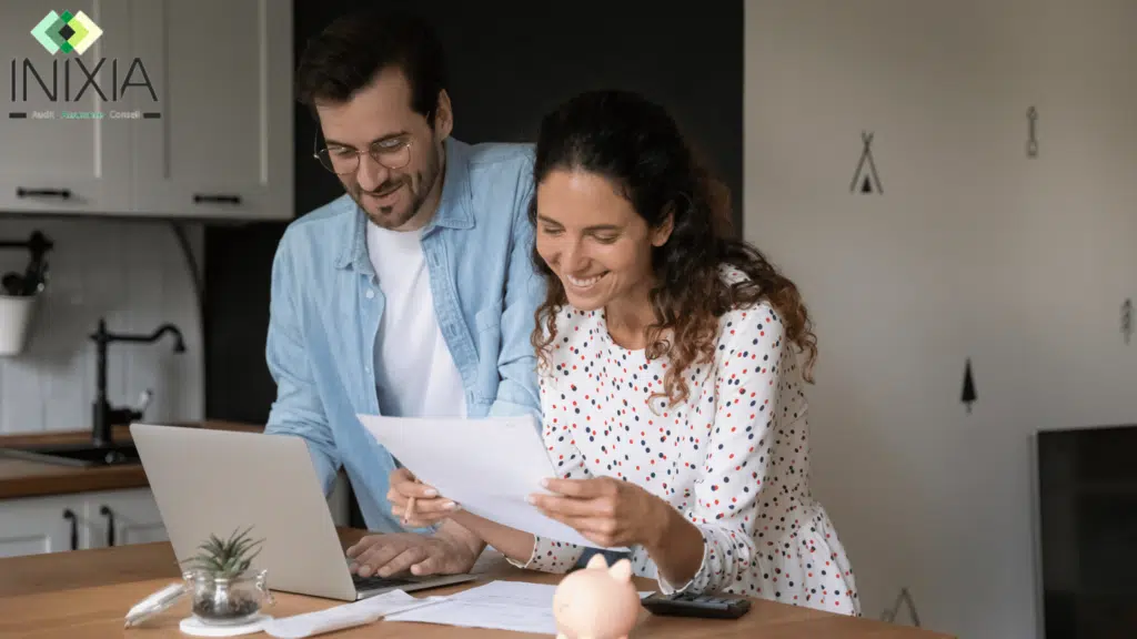 Un homme et une femme dans un salon avec le sourire qui regarde un contrat.