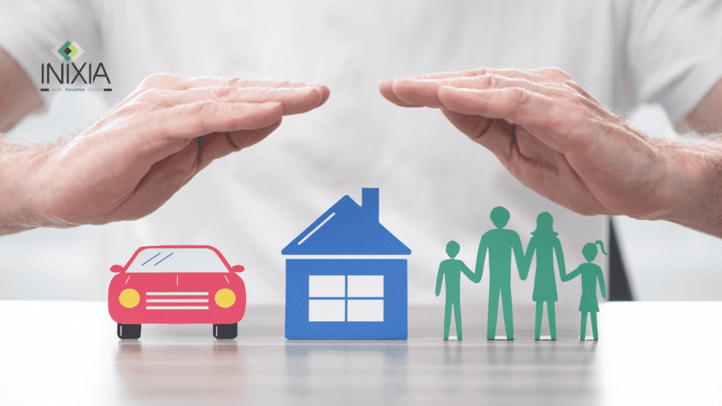 Une main au-dessus d'une représentation en carton d'une voiture, d'une maison et d'une famille.