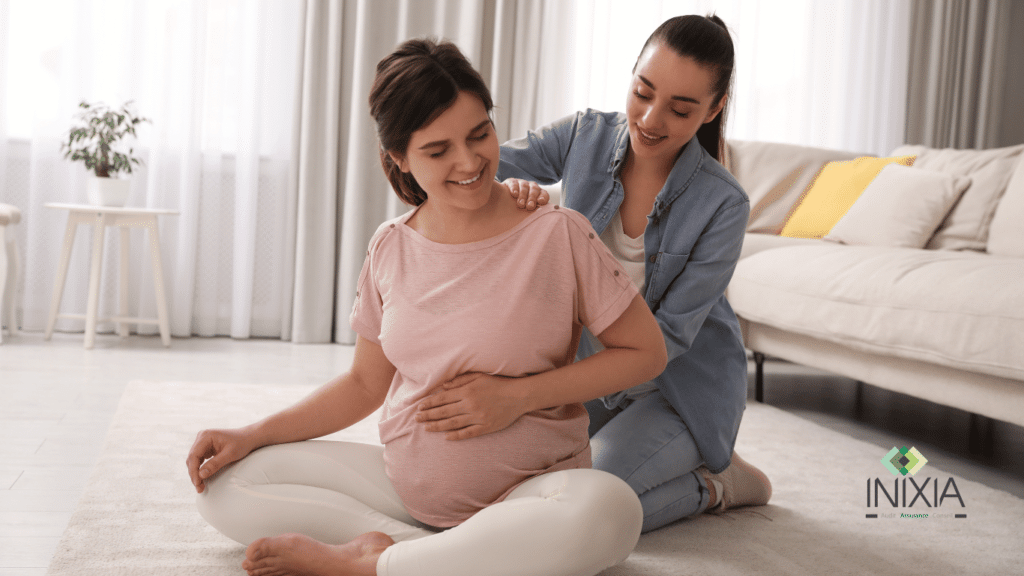 Une femme enceinte et un ami réalisent ensemble des étirements dans le confort de leur salon
