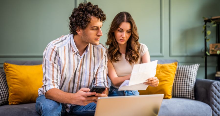 Un couple non marié en train de vérifier le contrat de leur assurance emprunteur