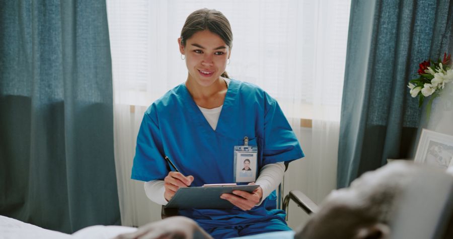 une infirmière assise dans la chambre de son patient