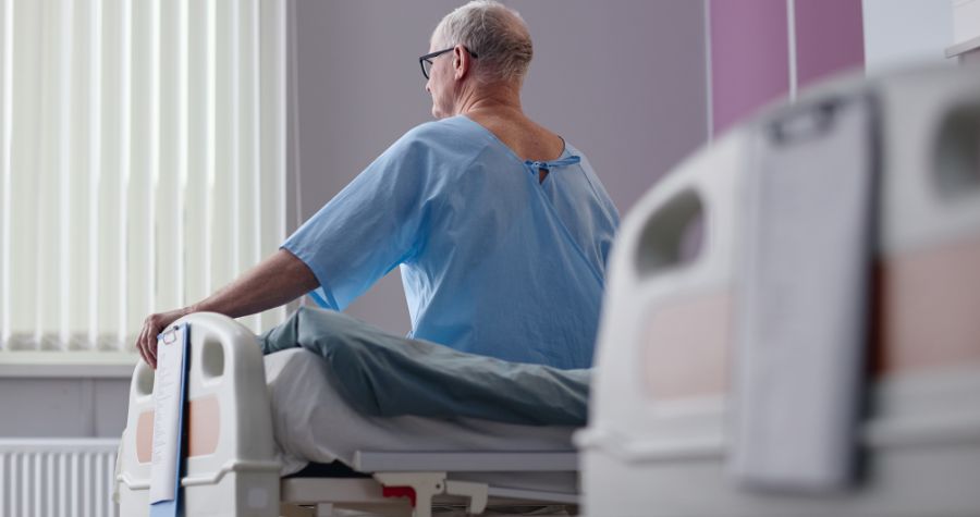 un patient assis sur son lit d'hôpital