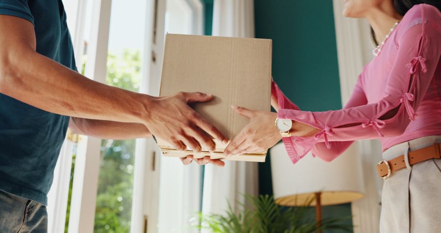 un livreur en train de livrer un colis à une cliente