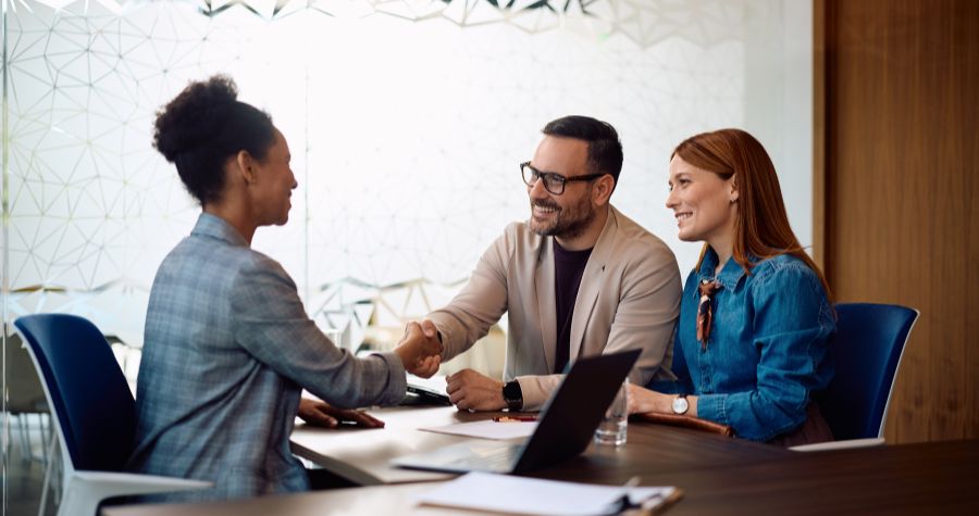 un couple d'emprunteur entrain de signer un contrat avec une conseillère