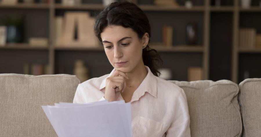 une femme en train de lire les lignes de son contrat d'assurance emprunteur