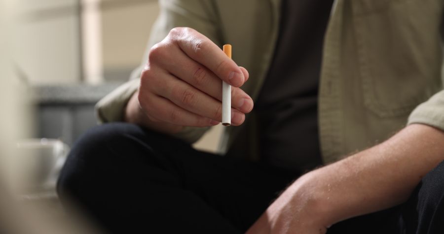 un gros plan sur un homme qui fume sa cigarette