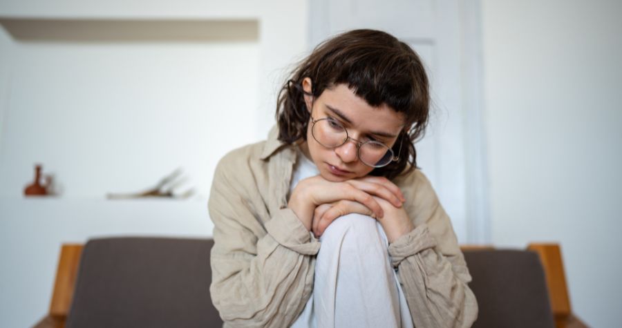 une femme en plein burnout, assise sur son canapé