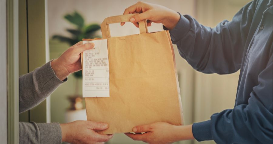 un livreur qui dépose un repas à une cliente