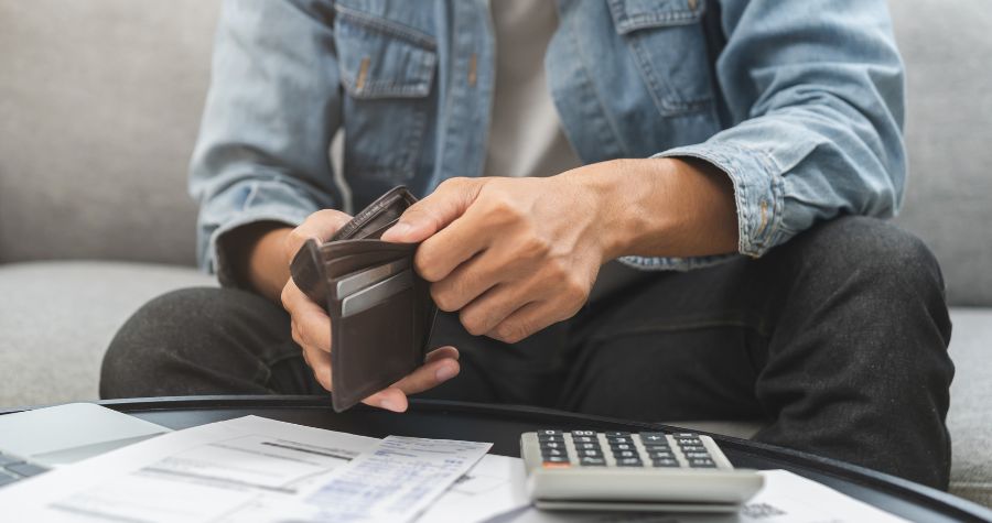 un homme qui fouille dans son portefeuille 